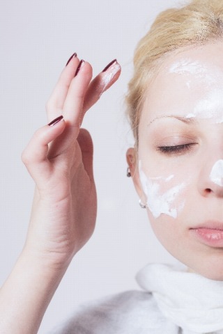 顔にクリームを塗る女性